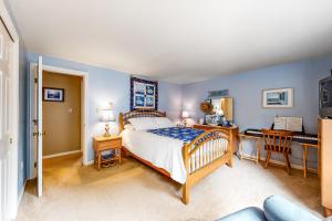 um quarto com uma cama, uma secretária e uma cama em Summer Daze em Edgartown