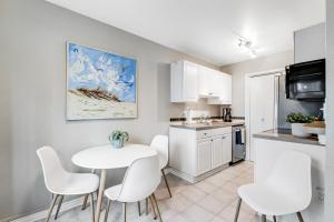 a kitchen with white chairs and a white table in a room at Seattle Sights in Seattle