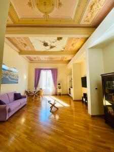 ein Wohnzimmer mit einem lila Sofa und einer Decke in der Unterkunft SUITE 188 - Via Roma in Palermo