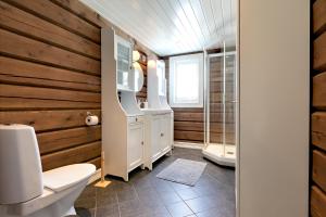 a bathroom with a toilet and a wooden wall at Utsikten in Sykkylven +9 photos
