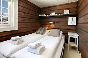 2 camas en una habitación con paredes de madera en Utsikten en Sykkylven