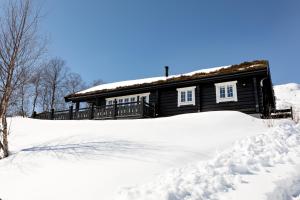 a log cabin with snow in front of it at Utsikten in Sykkylven