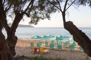 un gruppo di sedie e ombrelloni su una spiaggia di Papidakis Studios ad Agia Marina Nea Kydonias
