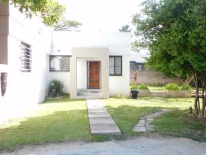 a white house with a red door in a yard at Okavango apartments in Lusaka