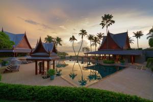 ein Resort mit Swimmingpool und Palmen in der Unterkunft Chiva-Som International Health Resorts in Hua Hin