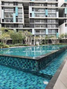 a swimming pool in front of a tall building at STUDIO SUITE HOMESTAY KLIA in Sepang