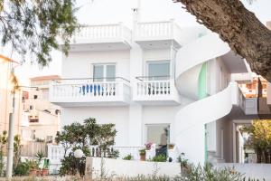 un edificio bianco con balconi bianchi di Papidakis Studios ad Agia Marina Nea Kydonias