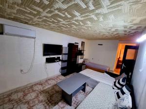 sala de estar con mesa y TV en el techo en три стаен лукс апартамент en Razgrad