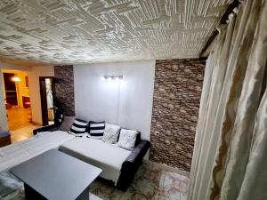 три стаен лукс апартамент في Razgrad: غرفة معيشة مع سرير وجدار من الطوب