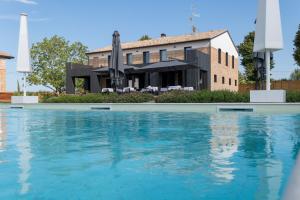 a house with a swimming pool in front of a building at Sei Sequoie in Ravenna