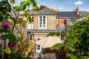 a house with an umbrella in front of it at Walsingham House - Peaceful Elevated - Near Oram's Arbour in Winchester