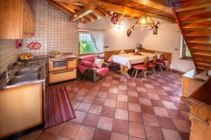 a kitchen and dining room with a table and chairs at Baita Mas Socina in Peio