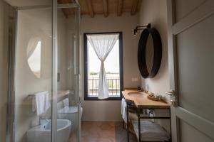un bagno con doccia, lavandino e finestra di Sei Sequoie Nature & Charme a Ravenna