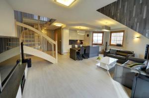 een woonkamer met banken en een trap in een huis bij Apartamenty EverySky - Prusa 2a-22 in Karpacz