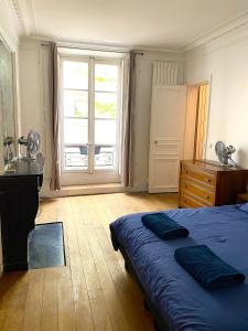 パリにあるReal Parisian apartment with 2 bedrooms and ACのベッドルーム1室(ベッド1台、ドレッサー、窓付)
