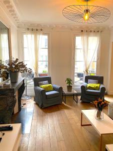 a living room with two chairs and a fireplace at Real Parisian apartment with 2 bedrooms and AC in Paris