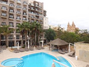 a swimming pool in front of a large building at Maritim Antonine Hotel & Spa in Mellieħa