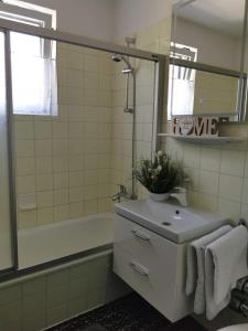 ein Badezimmer mit Waschbecken, Badewanne und Spiegel in der Unterkunft Apartment GoKaprun mit Blick auf die Berge in Kaprun + 23 Fotos