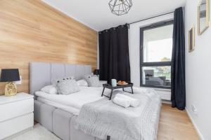 Riva Verona Apartments by Renters Prestige في كراكوف: غرفة نوم مع أريكة بيضاء ونافذة