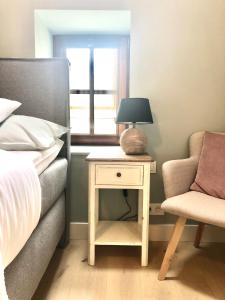 een slaapkamer met een bed en een tafel met een lamp en een stoel bij Winning De Zwaen in Hasselt