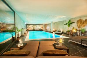 een woonkamer met een zwembad en een bank bij Designhotel ÜberFluss in Bremen