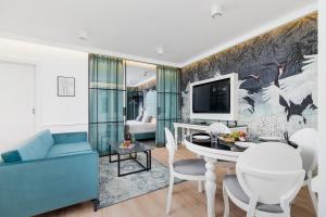 sala de estar con sofá azul y TV en Riva Verona Apartments by Renters Prestige en Cracovia