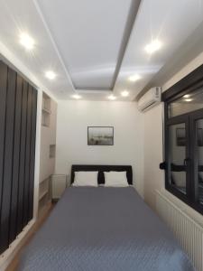Schlafzimmer mit einem Bett und einem Fenster in der Unterkunft Restoran Due Punti in Kuršumlija