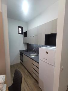 a small kitchen with a sink and a refrigerator at Restoran Due Punti in Kuršumlija