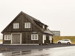 a barn with a car parked in a parking lot at Kristinsson Apartments in Grindavík