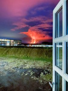 a view from a window of a fire in the distance at Kristinsson Apartments in Grindavík