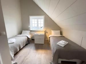 a attic room with two beds and a window at Kristinsson Apartments in Grindavík