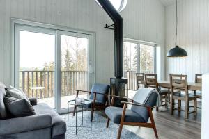 a living room with a couch and a table and chairs at Villabranten! Ski In - Ski Out, Bike In - Bike Out in Järvsö