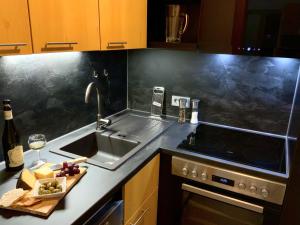 una cucina con lavandino e piano di lavoro con piatto di cibo di Hubertushof a Jungholz