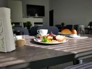 a table with a plate of food and a cup of coffee at Löwen Hotel in Radevormwald