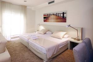 a white bedroom with a bed and a staircase at Bet Apartments - Apartments Catedral in Valencia