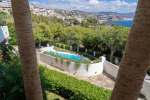 uma vista para uma piscina entre duas palmeiras em Casa de Luz em La Herradura