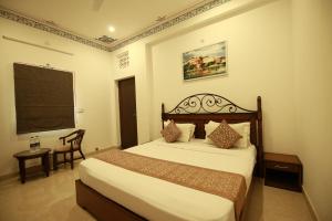 a hotel room with a bed and a chair at Hotel Casa by the lake in Udaipur