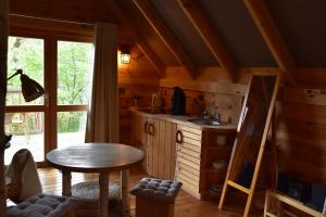 una cocina con mesa y fregadero en una cabaña en Cabane Lodge Domaine du Lac Chambon, en Murol