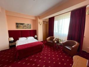 Hotel Class في كونستانتا: غرفة فندق بها سرير وسجادة حمراء +22 صورة