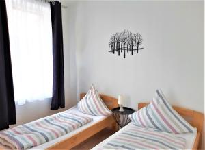 2 Betten mit gestreiften Kissen in einem Zimmer mit Fenster in der Unterkunft Citywohnung Südliche Innenstadt II in Halle an der Saale