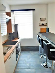 eine Küche mit Spüle und ein paar Stühlen in der Unterkunft Citywohnung Südliche Innenstadt II in Halle an der Saale