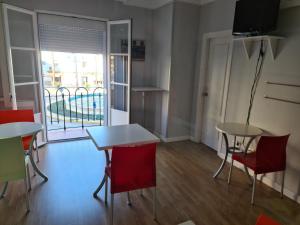 Habitación con 2 mesas, sillas y ventana en Hotel Dila, en Vélez-Málaga