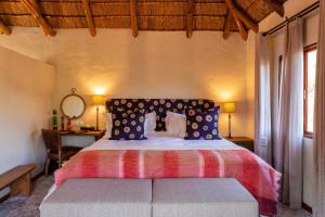 a bedroom with a bed and a desk and window at Lalibela Game Reserve Mark's Camp in Paterson