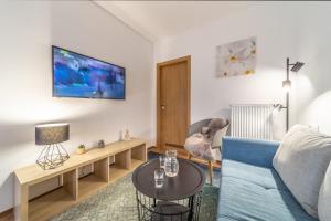 ein Wohnzimmer mit einem blauen Sofa und einem Tisch in der Unterkunft Aviatik apartments in Budweis