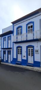 een blauw-wit gebouw met een balkon bij Moradia Machado in Topo