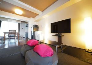 een woonkamer met 2 roze kussens en een flatscreen-tv bij Asakusa Eight -Tokyo Condominium Hotel- in Tokyo
