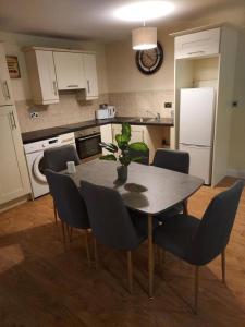 eine Küche mit einem Tisch und Stühlen sowie eine Küche mit einem Kühlschrank in der Unterkunft Shannon Oaks Apartments in Portumna