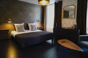 a hotel room with a bed and a mirror at La Villa des Sables in Concarneau