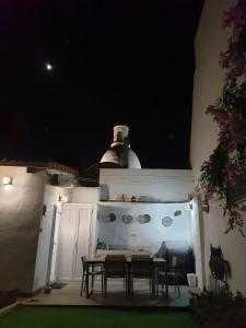 a patio with a table and chairs at night at Lala´s house in Ingenio