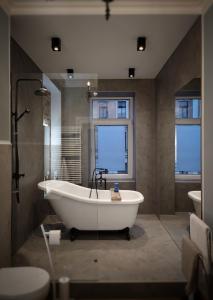 ein großes Bad mit einer Badewanne und einem Waschbecken in der Unterkunft Flat in neo country style aus Gründerzeit bis 6 Person in Leipzig